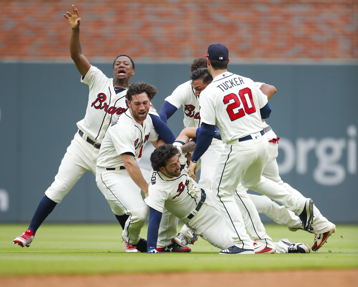 Dansby Swanson is mobbed by teammates after his walk-off single gave the Braves a wild 10-9 victory. (AP Photo/Todd Kirkland)