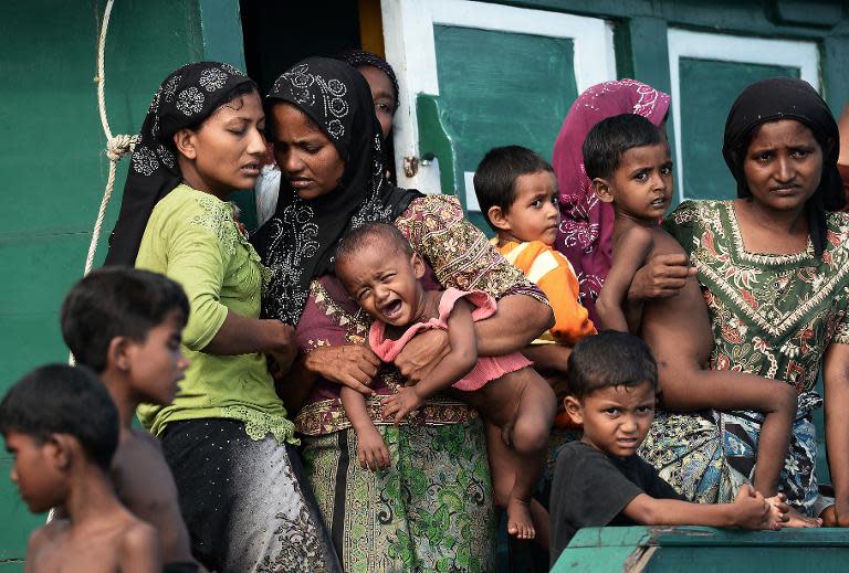 Rohingya migrant women and children stand on a boat drifting in Thai waters off Koh Lipe island on May 14, 2015