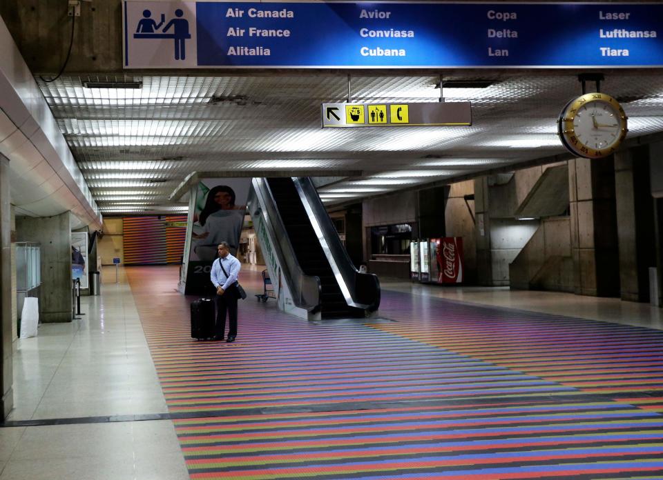 A passenger stands next to Air France desk at Simon Bolivar International Airport in Maiquetia near Caracas, Venezuela, Saturday, Dec. 14, 2013. Venezuelan bomb experts are inspecting a grounded Air France flight after being tipped off by French authorities that a terrorist group may be planning to detonate an explosive device in midair. Venezuelan Interior Minister Miguel Rodriguez Torres told state TV that a team of more than 60 technicians are performing an exhaustive search of the aircraft that will take several hours before the flight can be reprogrammed.(AP Photo/Fernando Llano)