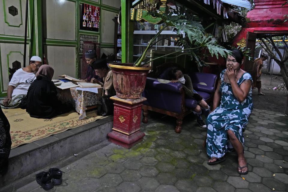 Nur, right, a trans woman, takes a cigarette break as other attend a Quran reading class at Al-Fatah Islamic school in Yogyakarta, Indonesia, Sunday, Nov. 6, 2022. On the outskirts of the Indonesian city that's home to many universities, the small boarding school is on a mission that seems out of place in a nation with more Muslim citizens than any other. Its students are transgender women. (AP Photo/Dita Alangkara)