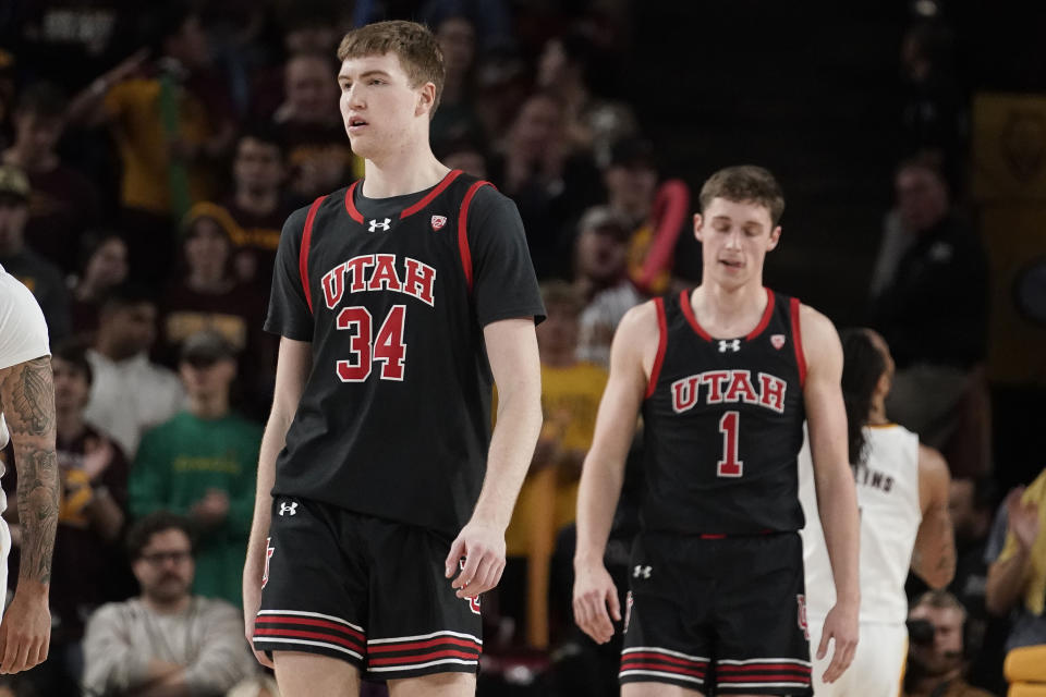 Utah's Lawson Lovering (34) and Ben Carlson (1) stand on the court late in the second half of the team's NCAA college basketball game against Arizona State on Thursday, Jan. 4, 2024, in Tempe, Ariz. (AP Photo/Darryl Webb)