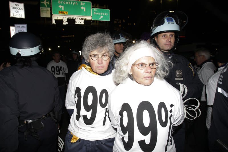 A group of Occupy Wall Street Protesters get arrested after sitting on the street blocking cars from crossing the Brooklyn Bridge after a rally in Foley Square In New York City on November 17, 2011. On October 1, 2011, about 400 Occupy Wall Street protesters were arrested by New York City police when they blocked traffic on the Brooklyn Bridge. File Photo by John Angelillo/UPI