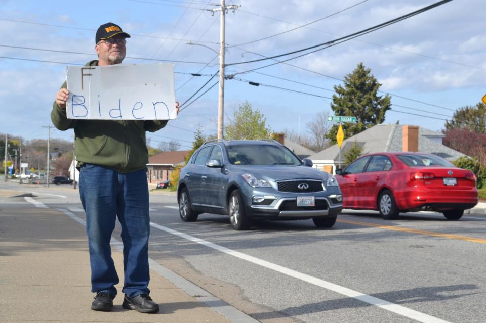 Tiverton Budget Committee member holds a sign on Main Road. Due to explicit content, The Daily News has modified the image.