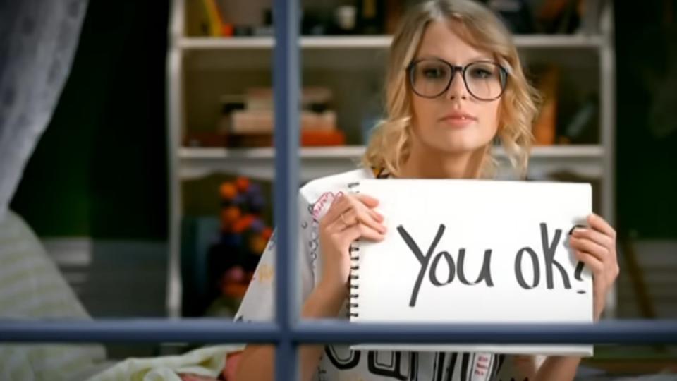 Taylor Swift holding up a sign that says 