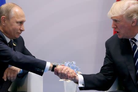 FILE PHOTO: FILE PHOTO: U.S. President Donald Trump shakes hands with Russian President Vladimir Putin during the their bilateral meeting at the G20 summit in Hamburg, Germany, July 7, 2017. REUTERS/Carlos Barria/File Photo/File Photo