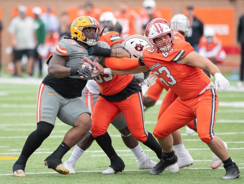 Former LSU and Navarre High School DL Jordan Jefferson (99) engages National Team offensive lineman former Wisconsin OL Tanor Bortolini (63) during the Reese's Senior Bowl in Mobile, Alabama on Saturday, Feb. 3, 2024.