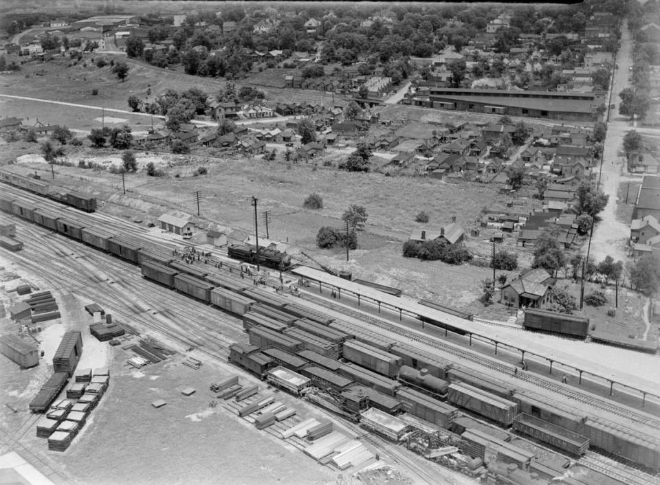 Aerial photo of the Southern Railway System yards off South Broadway showing workers laying a 975-foot rail at one operation in June 1939. At the center of the photo is Davis Bottoms with De Roode Street running left to right. Davis Botton was later torn down to make way
