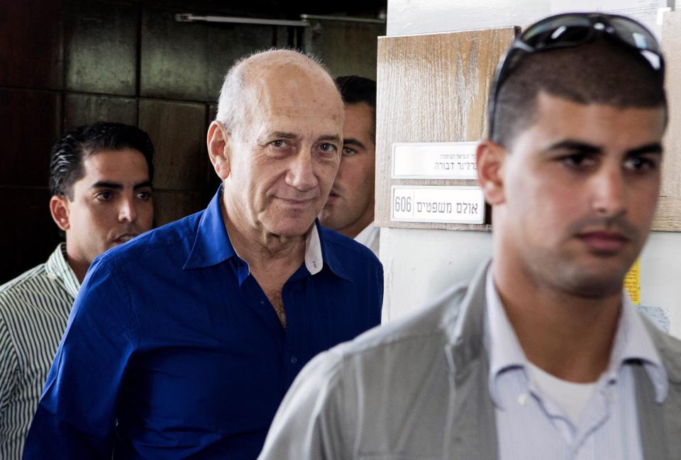 Israel's former Prime Minister Ehud Olmert, center, leaves the Tel Aviv District Court in Israel, Tuesday, May 13, 2014. Olmert was sentenced on Tuesday to six years in prison for his role in wide-ranging bribery case, capping a stunning fall from grace for one of the most powerful men in the country. (AP Photo/Jack Guez, Pool)