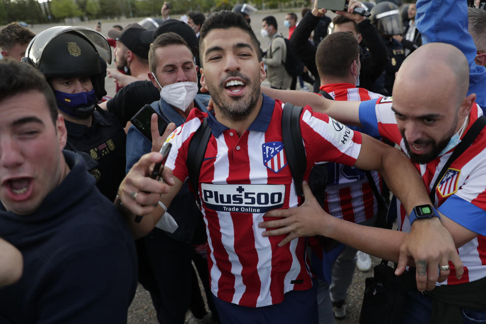 Atletico Madrid's Luis Suarez celebrates with supporters after the Spanish La Liga soccer match between Atletico Madrid and Valladolid at the Jose Zorrilla stadium in Valladolid, Spain, Saturday, May 22, 2021. Atletico won 2-1 and clinches its 11th Spanish La Liga title. (AP Photo/Manu Fernandez)