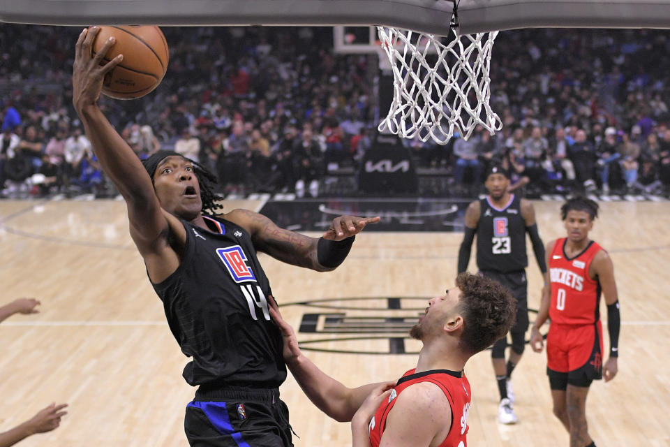 Los Angeles Clippers guard Terance Mann, left, shoots as Houston Rockets forward Bruno Fernando defends during the first half of an NBA basketball game Thursday, Feb. 17, 2022, in Los Angeles. (AP Photo/Mark J. Terrill)
