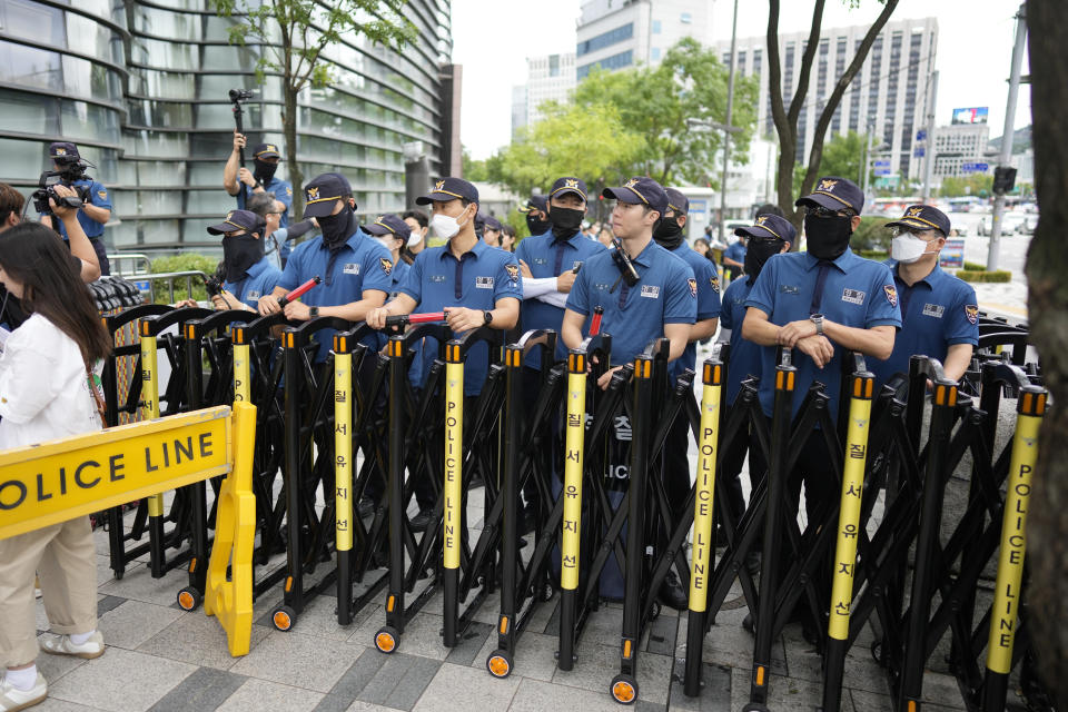 Police officers stand guard outside of a building which houses Japanese Embassy, in Seoul, South Korea, Thursday, Aug. 24, 2023. The operator of the tsunami-wrecked Fukushima Daiichi nuclear power plant says it has begun releasing its first batch of treated radioactive water into the Pacific Ocean — a controversial step, but a milestone for Japan's battle with the growing radioactive water stockpile. (AP Photo/Lee Jin-man)