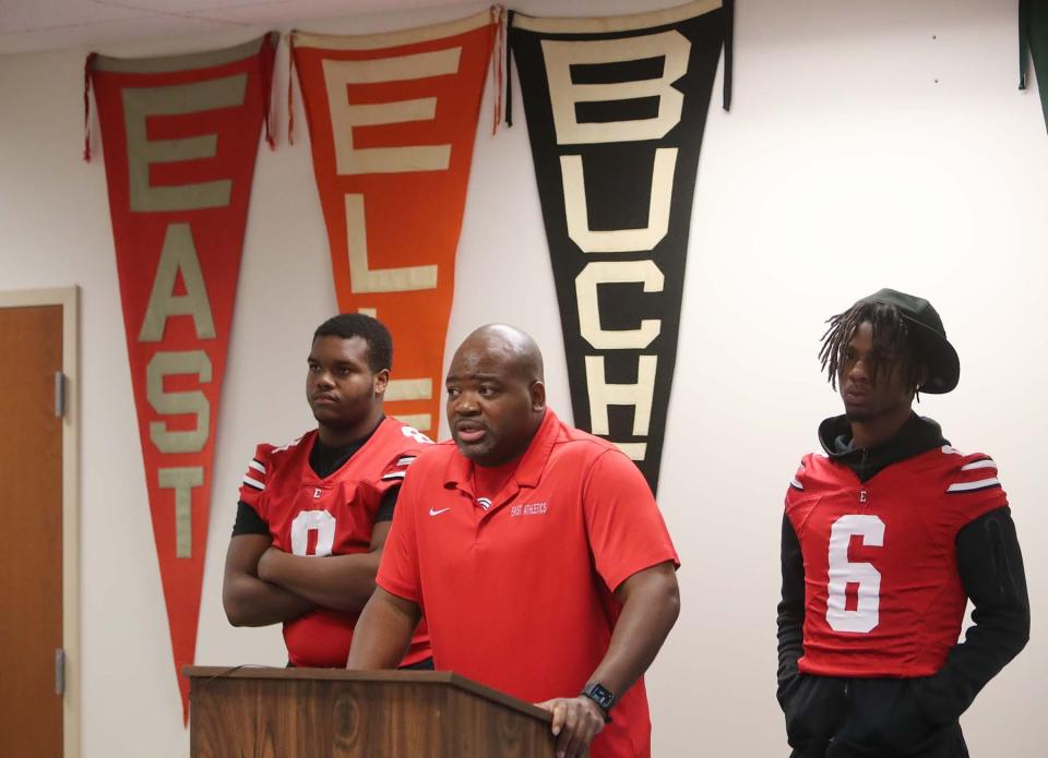 East High School head football coach Marques Hayes, center, speaks during the Akron Public Schools Football Media Day as he stands between players Antonio Sandel-Bascomb, left, and Ronin Kelley on Wednesday in Akron. 
