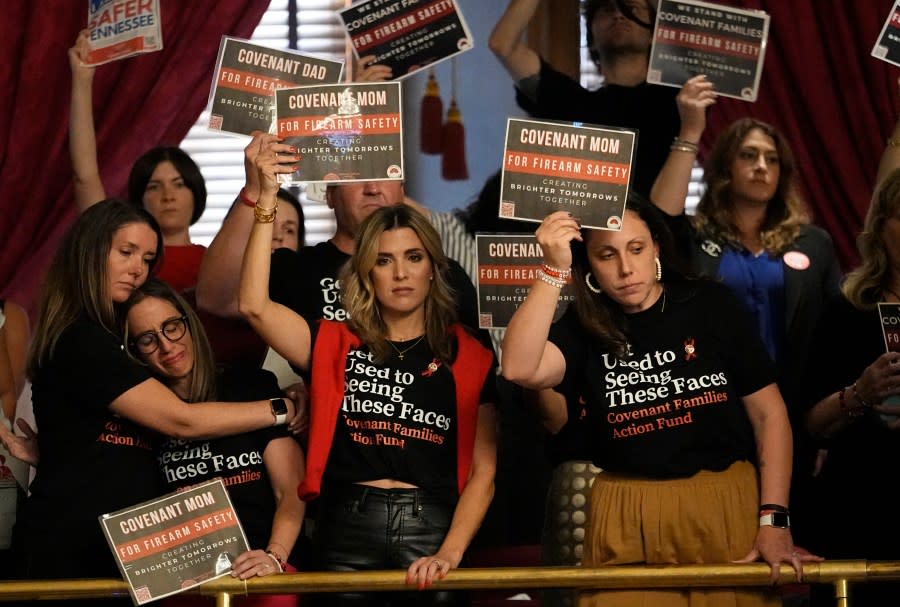 FILE - Parents from The Covenant School comfort each other and hold signs above the House floor advocating for gun law reform during a special session of the state legislature on public safety Monday, Aug. 28, 2023, in Nashville, Tenn. Throughout the corridors of many state Capitols, families are sharing emotionally gutting stories of tragedy caused by mass school shootings with the hope that revealing their trauma will convince lawmakers on either side of the political aisle to reconsider firearm policies. (AP Photo/George Walker IV, File)