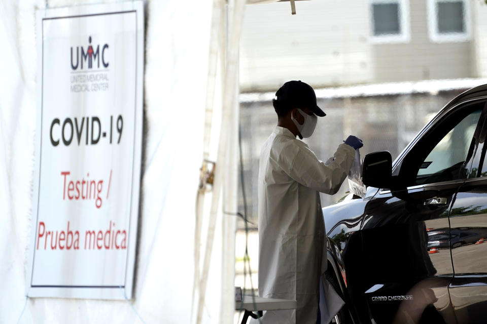 A healthcare worker gathers information from a patient at a United Memorial Medical Center COVID-19 testing site Thursday, July 16, 2020, in Houston. (AP Photo/David J. Phillip)