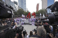 Supporters and relatives of 43 missing university students hold placards with photos of their loved as they pose for a photo in front of a monument in their remembrance, on the seventh anniversary of children's disappearance, in Mexico City, Sunday, Sept. 26, 2021. Relatives continue to demand justice for the Ayotzinapa students who were allegedly taken from the buses by the local police and handed over to a gang of drug traffickers. (AP Photo/Marco Ugarte)