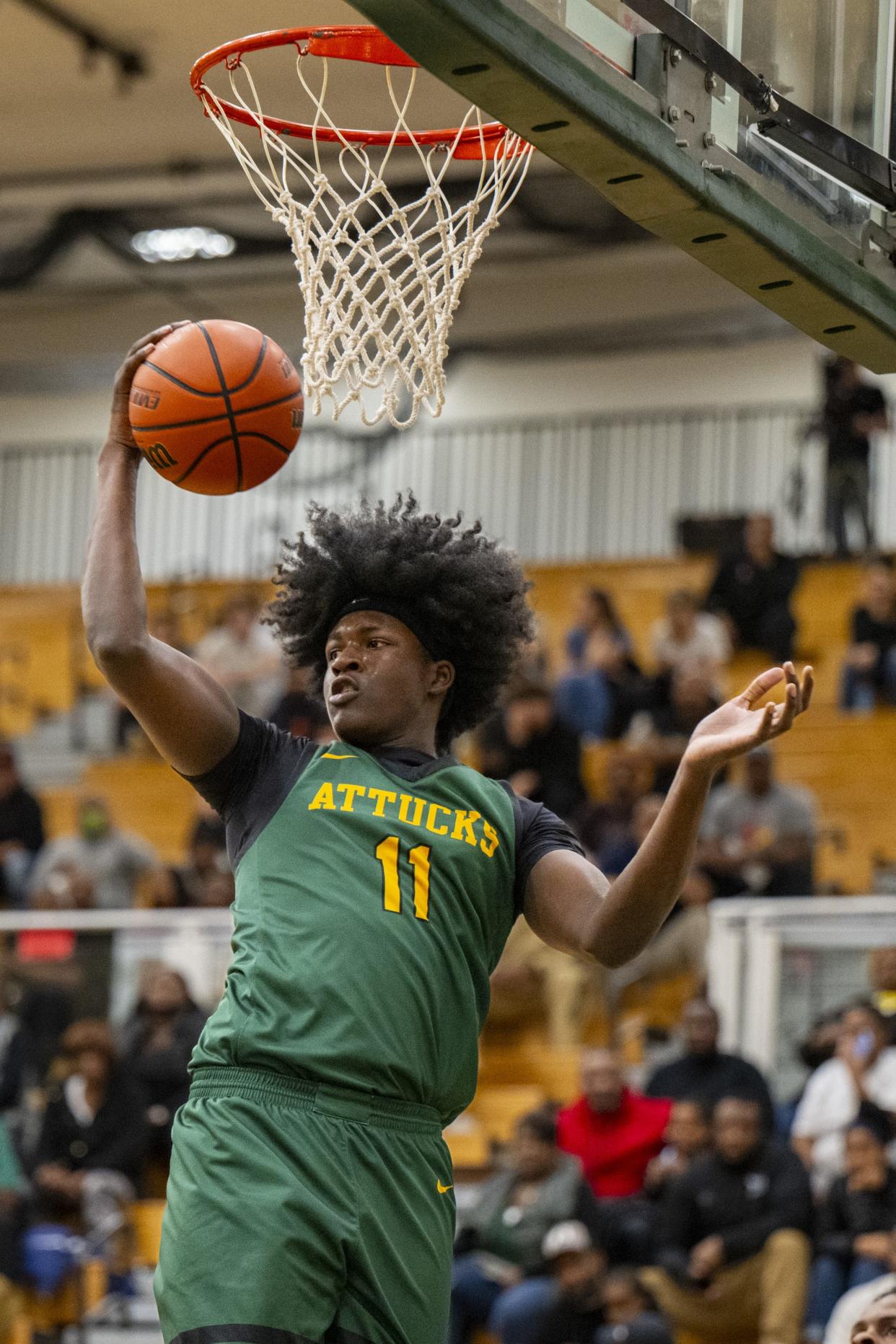 Indianapolis Crispus Attucks High School junior Dezmon Briscoe (11) pulls down a rebound during the first half of an IHSAA basketball game against Lawrence North High School, Tuesday, Dec. 19, 2023, at Lawrence North High School.