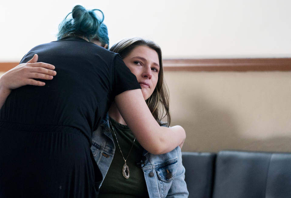 Khloe Warne, 12, hugs her mother, Alyssa, as she becomes emotional while explaining Khloe's school experience, Thursday, May 18, 2023, at their bakery Beef Cakes in Grants Pass, Ore. Khloe was put on shortened school days by her school district after incidents in which she fought with students and threw a desk in outbursts her mother, Alyssa, attributes to a failure to support her needs. Now she only attends school one day a week for two hours, and hasn't been on a regular school schedule for years, instead spending much of her time at her mother's bakery or at the local library. (AP Photo/Lindsey Wasson)
