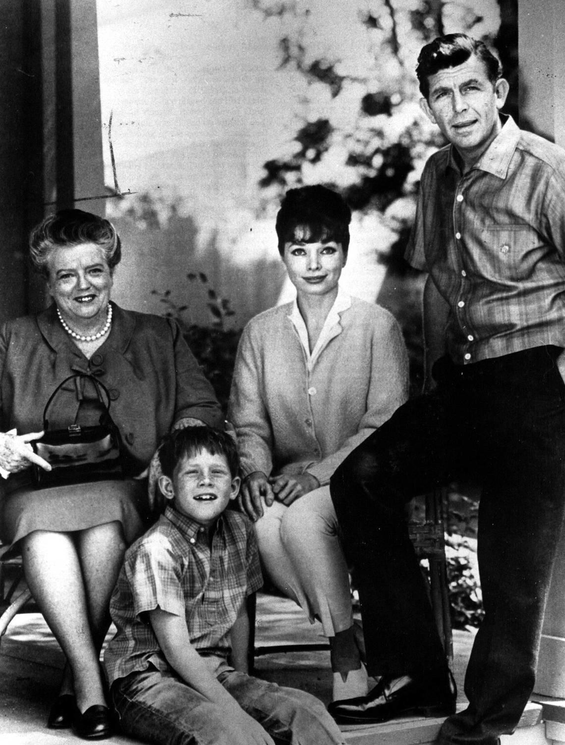 The cast of The Andy Griffith Show: Frances Bavier, as Aunt Bee Taylor, Ron Howard, as Opie Taylor, Aneta Corsaut, as Helen Crump and Andy Griffith, as Sheriff Andy Taylor.