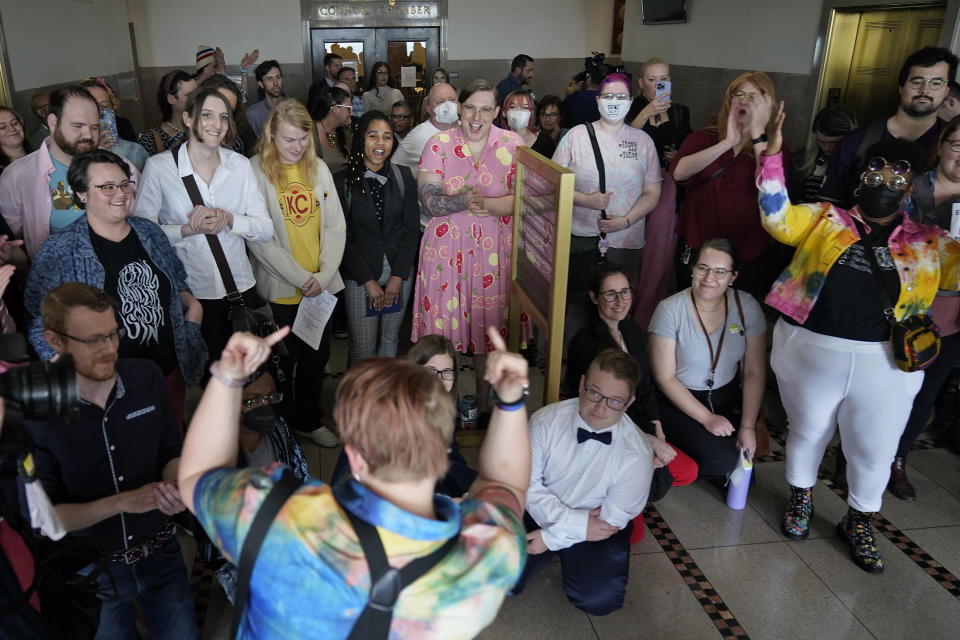 Supporters of a resolution that would make Kansas City, Mo, a sanctuary city for transgender people celebrate outside of city council chambers after a committee approved the resolution, sending it to the full council for consideration, Wednesday, May 10, 2023, in Kansas City, Mo. The move comes in the wake of Missouri legislators voting to ban gender-affirming care and trans athletes. (AP Photo/Charlie Riedel)