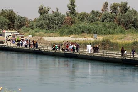 Iraqis cross the floating bridge between east and west of Mosul, Iraq, July 21, 2017. REUTERS/Khalid Al-Mousily