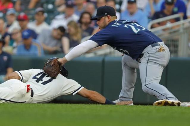 Minnesota Twins' Carlos Correa, left, follows through on a two-run