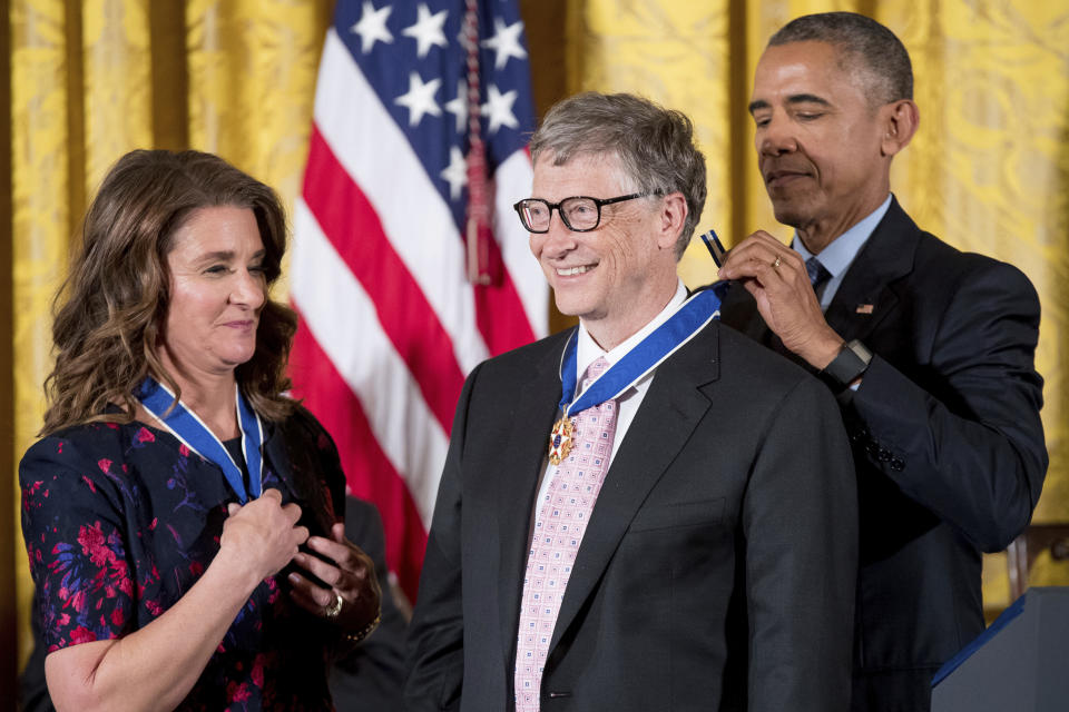 President Barack Obama, accompanied by Melinda Gates, left, presents the Presidential Medal of Freedom to Bill Gates, center, during a ceremony in the East Room of the White House, Tuesday, Nov. 22, 2016, in Washington. Obama is recognizing 21 Americans with the nation's highest civilian award, including giants of the entertainment industry, sports legends, activists and innovators. (AP Photo/Andrew Harnik)