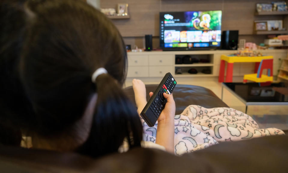 kid pointing a remote at the tv