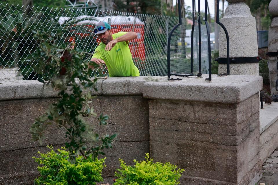 Dan Muse of Coastline Landscape tosses debris to help clean up Flagler College Friday, Sept. 30, 2022 in St. Augustine. Hurricane Ian, that was later reduced to a tropical storm, ripped through the region Thursday bringing winds, rain, flooded roads, power outages and downed trees. 