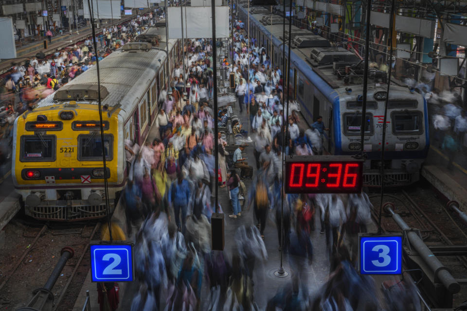 Indian commuters get off trains at the Church Gate railway station in Mumbai, India, Monday, Nov. 14, 2022. The 8 billionth baby on Earth is about to be born on a planet that is getting hotter. But experts in climate science and population both say the two issues aren't quite as connected as they seem. (AP Photo/Rafiq Maqbool)