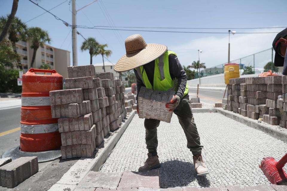 Esteban Rafil of Tincher Concrete Construction   places pavers in the median of Estero Boulevard on Fort Myers Beach on Monday June, 29, 2020. Temperatures are in the low 90&#39;s with a feels like temperature in the low 100&#39;s. The heat index has been low hundreds over the last week. 