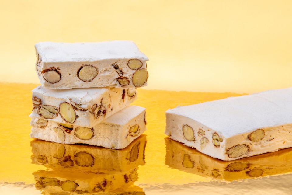 eid al fitr food nougat with almonds and hazelnuts on a golden background where it is reflected