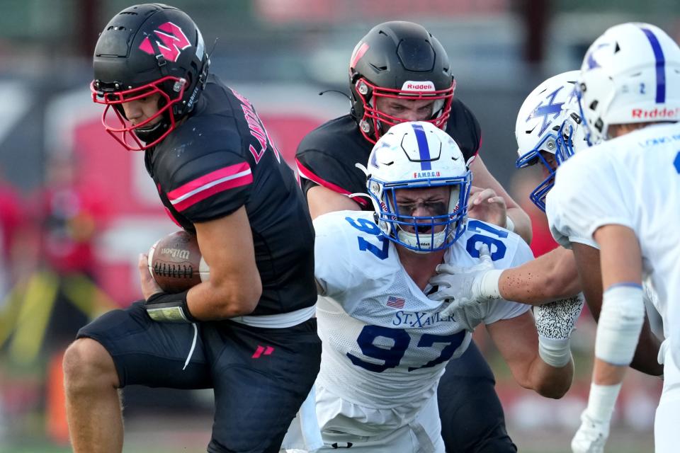 St. Xavier defensive lineman Ted Hammond, shown covering Lakota West's quarterback in their 2022 game, is a unanimous four-star recruit heading to Michigan.
