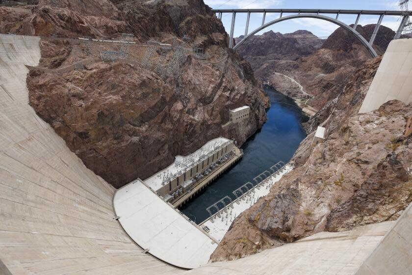 Hoover Dam, NV - June 29: A view of Hoover Dam and water flowing in the outflow area of the dam located on the border of Nevada and Arizona, where water is released back into the Colorado River and looking up to the Mike O'Callaghan-Pat Tillman Memorial Bridge Tuesday, June 29, 2021. The lower water levels are reducing the power that Hoover Dam's electrical turbines generate. Lake Mead is at its lowest level in history since it was filled 85 years ago. The ongoing drought has made a severe impact on Lake Mead and a milestone in the Colorado River's crisis. High temperatures, increased contractual demands for water and diminishing supply are shrinking the flow into Lake Mead. Lake Mead is the largest reservoir in the U.S., stretching 112 miles long, a shoreline of 759 miles, a total capacity of 28,255,000 acre-feet, and a maximum depth of 532 feet. (Allen J. Schaben / Los Angeles Times)