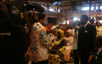 FILE - In this Sunday, Sept. 15, 2013 file photo, T.B. Joshua, second left, conducts a service at the Synagogue, Church of All Nations, in Lagos Nigeria. T.B. Joshua's Synagogue, Church of All Nations has branches around the world, and a recent YouTube video even credits him with predicting the disappearance of Malaysian Airlines Flight MH370. Joshua is one of the best-known preachers in Africa and among the most profitable in Nigeria, the go-to faith healer and spiritual guide for leaders such as the late Ghanaian president John Atta Mills, Malawian president Joyce Banda and former Zimbabwean prime minister Morgan Tsvangirai. The man who says he comes from the poor village of Arigidi is worth between $10 and $15 million based on assets, according to Forbes magazine, which in 2011 estimated his personal wealth. The church holds some 15,000 people with outside tents for the overflow and Sunday services are beamed worldwide. Yet critics say this wildly popular televangelist hinders efforts to curtail the spread of HIV and tuberculosis with testimonies by church-goers that faith and his holy water can cure both. He is also accused of taking advantage of his followers and tightly controlling those closest to him, who call him "Daddy."(AP Photo/Carley Petesch, file)