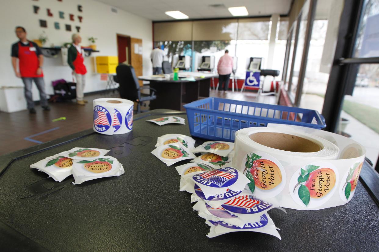 Georgia voting stickers sit atop an extra voting machine in Athens. Ga.