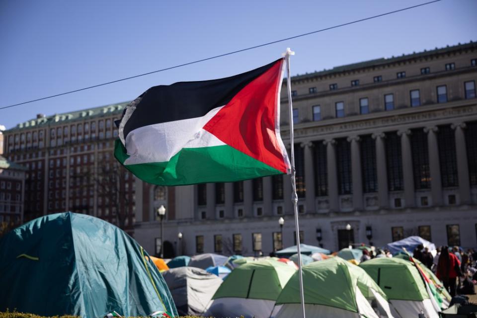 A Palestinian flag waves above the encampment. Melissa Bender/NurPhoto/Shutterstock