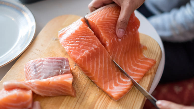 person cutting salmon filet