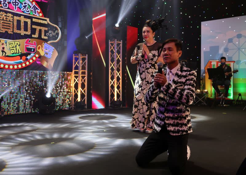 Getai veterans Wang Lei and Liu Ling Ling offer prayers at an altar before a live streaming getai show at a studio in Singapore