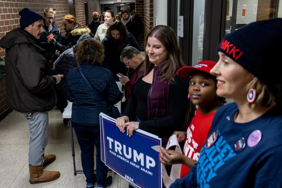 Volunteers are on hand to give out stickers as Iowans register for the Caucuses