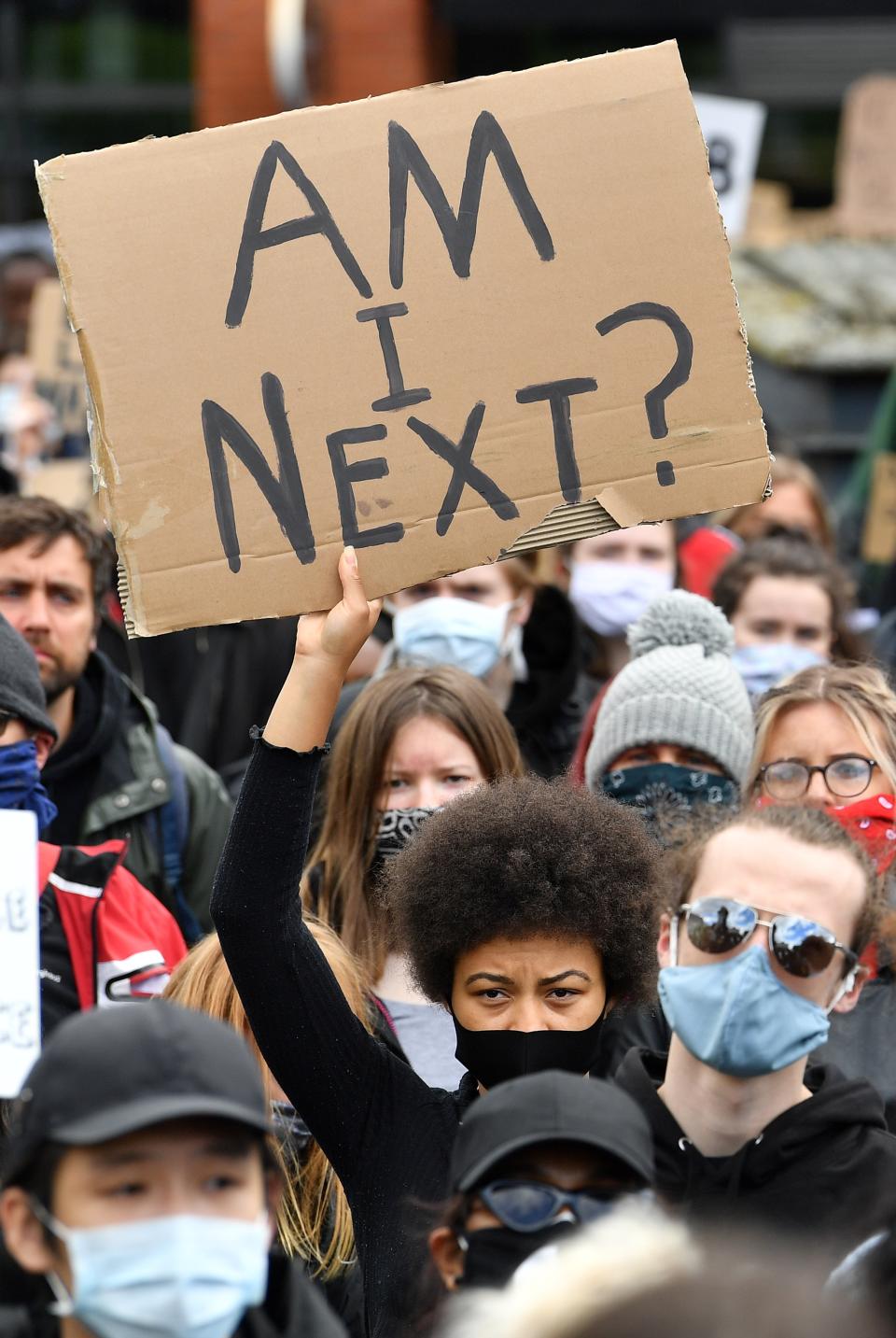 Protesters hold placards as they attend a demonstration in Manchester, northern England, on June 6, 2020, to show solidarity with the Black Lives Matter movement in the wake of the killing of George Floyd, an unarmed black man who died after a police officer knelt on his neck in Minneapolis. - The United States braced Friday for massive weekend protests against racism and police brutality, as outrage soared over the latest law enforcement abuses against demonstrators that were caught on camera. With protests over last week's police killing of George Floyd, an unarmed black man, surging into a second weekend, President Donald Trump sparked fresh controversy by saying it was a "great day" for Floyd. (Photo by Paul ELLIS / AFP) (Photo by PAUL ELLIS/AFP via Getty Images)