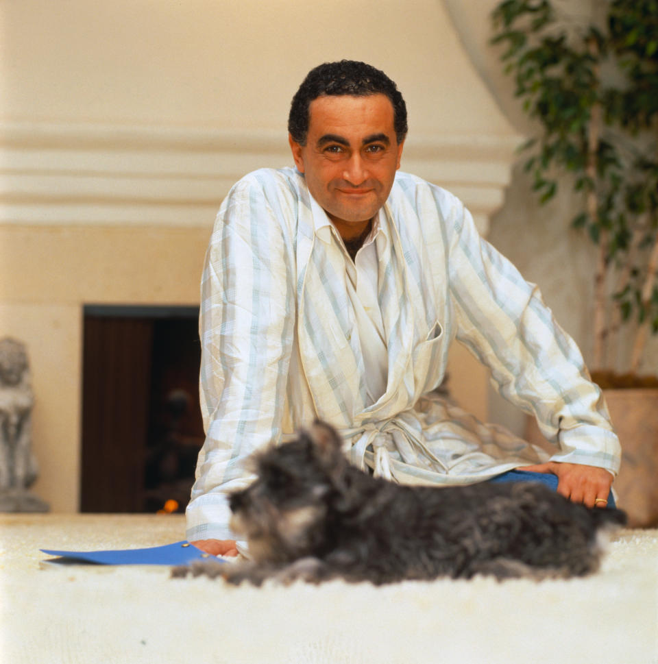 Dodi Fayed sits on the ground with his dog