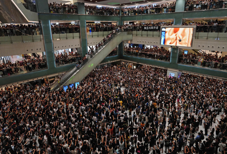 Local residents sing a theme song written by protesters "Glory be to thee" at a shopping mall in Hong Kong Wednesday, Sept. 11, 2019. Hong Kong Chief Executive Carrie Lam reassured foreign investors Wednesday that the Asian financial hub can rebound from months of protests, despite no sign that the unrest will subside. (AP Photo/Vincent Yu)