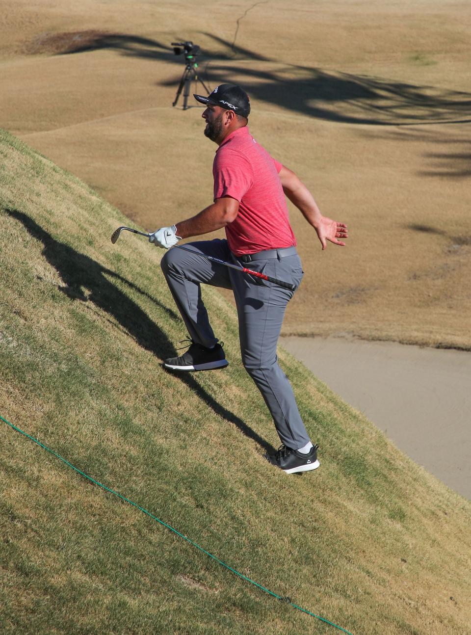 Jon Rahm climbs back toward the green after hitting into a low area behind the 16th green during the American Express on the Stadium Course at PGA West in La Quinta, Calif., Sunday, January 23, 2022.