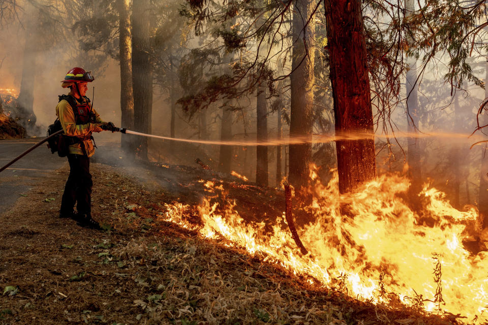 CORRECTS NAME TO GABE BARRIO INSTEAD OF JULIAN PELL - Captain Gabe Barrio sprays water on the Mosquito Fire burning along Michigan Bluff Rd. in unincorporated Placer County, Calif., on Wednesday, Sept. 7, 2022. (AP Photo/Noah Berger)