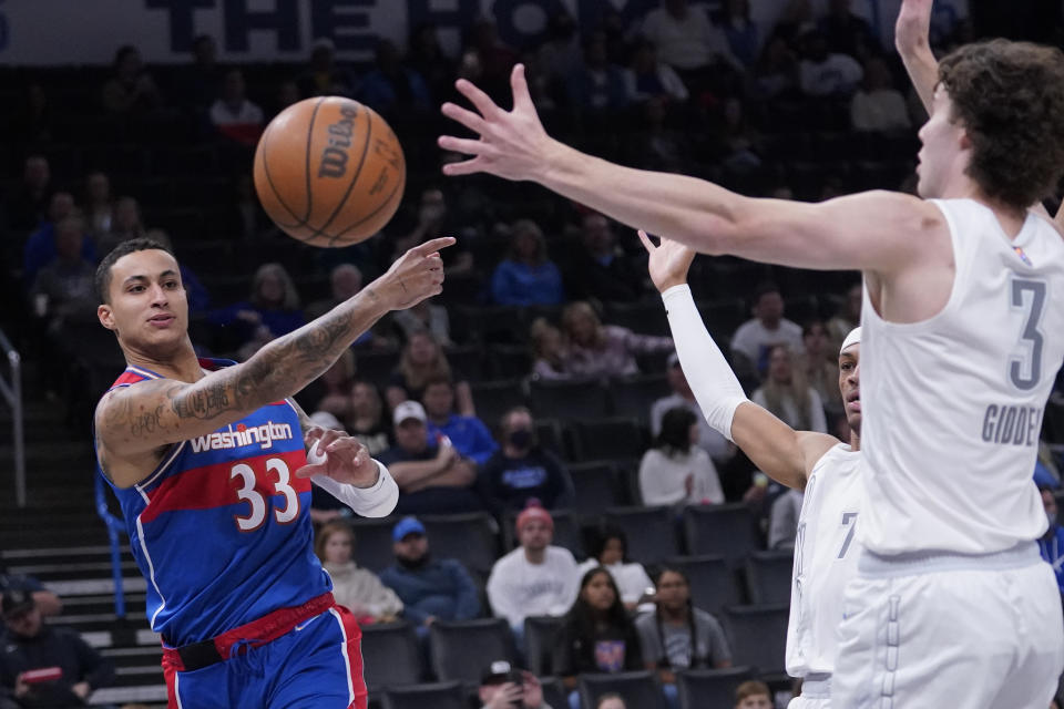 Washington Wizards forward Kyle Kuzma (33) passes around Oklahoma City Thunder guard Josh Giddey (3) in the first half of an NBA basketball game Friday, Nov. 26, 2021, in Oklahoma City. (AP Photo/Sue Ogrocki)