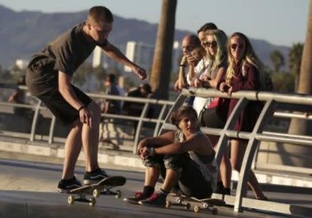 People watch a skateboarder at the Venice Skatepark in Venice, California November 7, 2014. REUTERS/Jonathan Alcorn