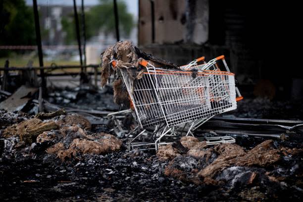 This photograph taken on 29 June 2023 in Brest, western of France shows shopping carts at a Biocoop, an organic supermarket partly burnt (AFP via Getty Images)