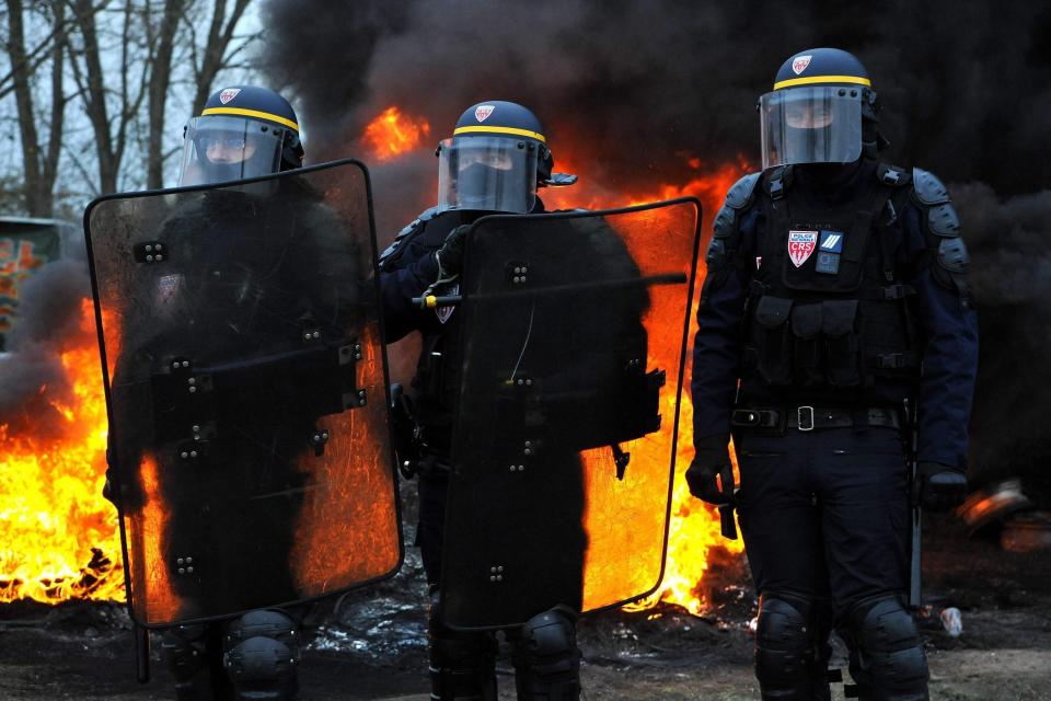 Riot police stand near a fire as they evacuate Yellow Vests blocking the road during a demonstration in Crespin: AFP/Getty Images