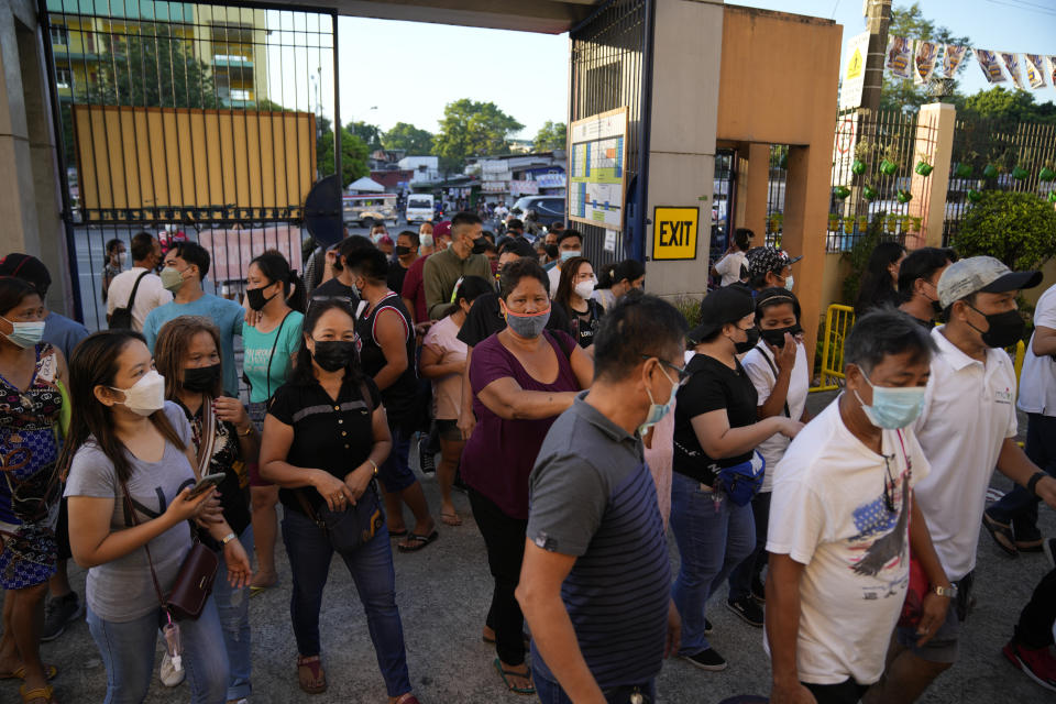 Voters enter a polling center Monday, May 9, 2022 in Quezon City, Philippines. Filipinos were voting for a new president Monday, with the son of an ousted dictator and a champion of reforms and human rights as top contenders in a tenuous moment in a deeply divided Asian democracy. (AP Photo/Aaron Favila)