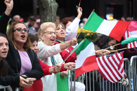 Women wave flags during the 74th Annual Columbus Day Parade in Manhattan, New York, U.S., October 8, 2018. REUTERS/Shannon Stapleton